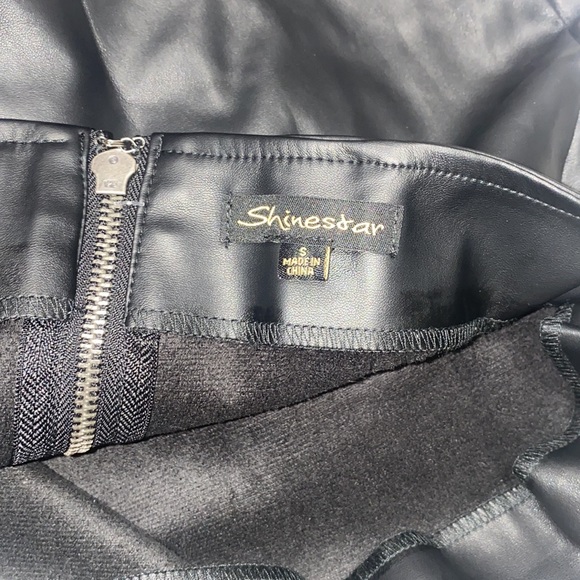 Mini black faux leather skirt with soft lining and side pleating. - Picture 3 of 5